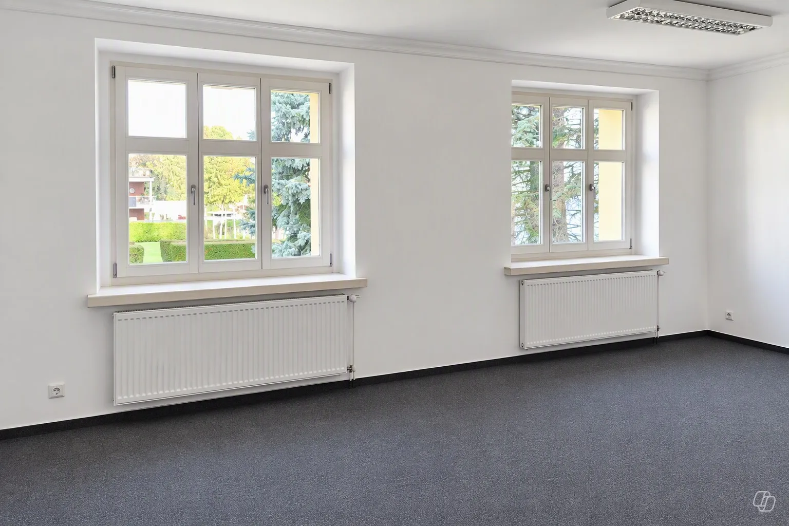 Büroraum mit Fenster, Heizkörper und Wandtypografie